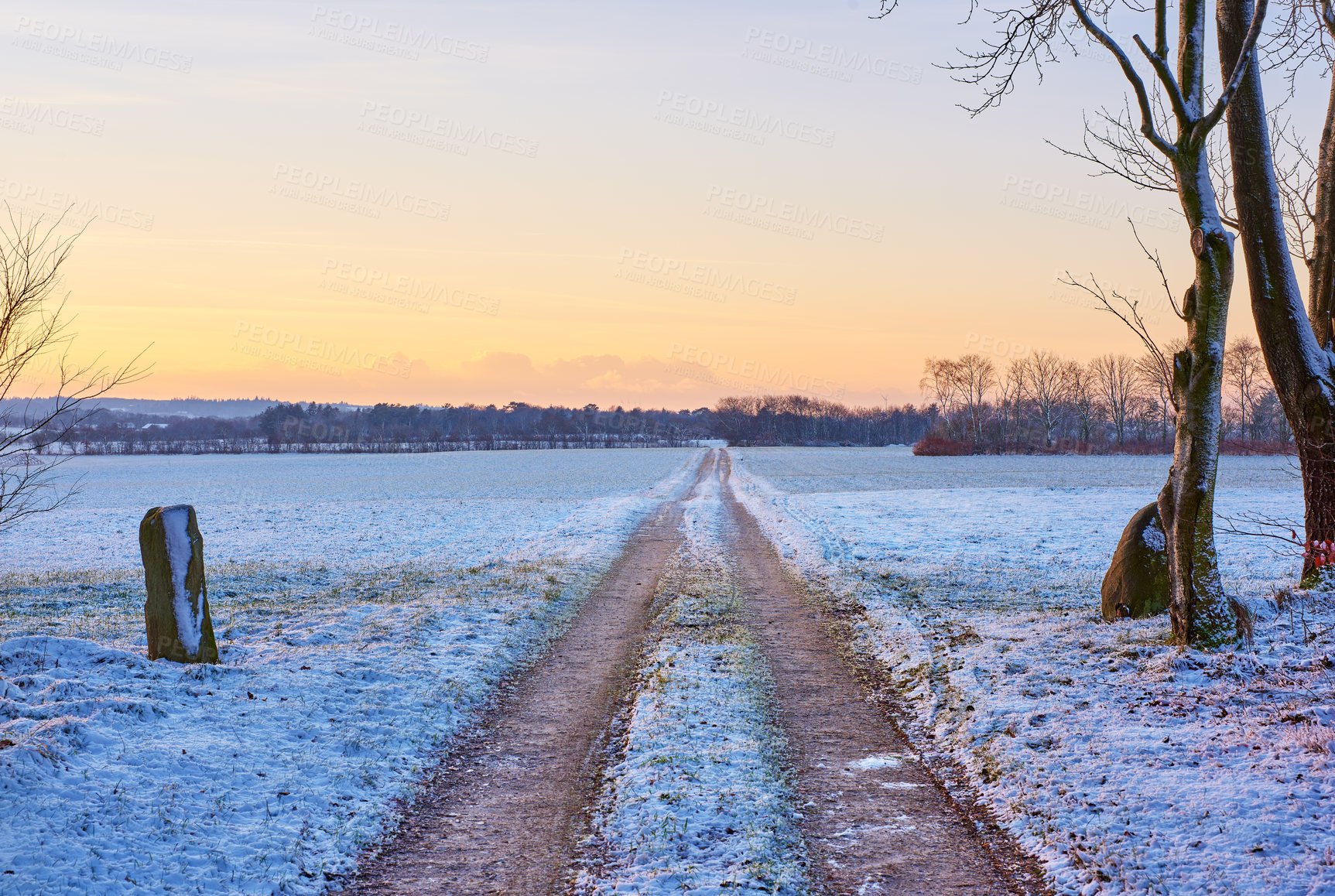 Buy stock photo Landscape, road and snow on field with sunrise for winter season, nature wallpaper and Christmas holiday. Frozen ground, countryside and ice on path way with twilight for peace and vacation in Poland