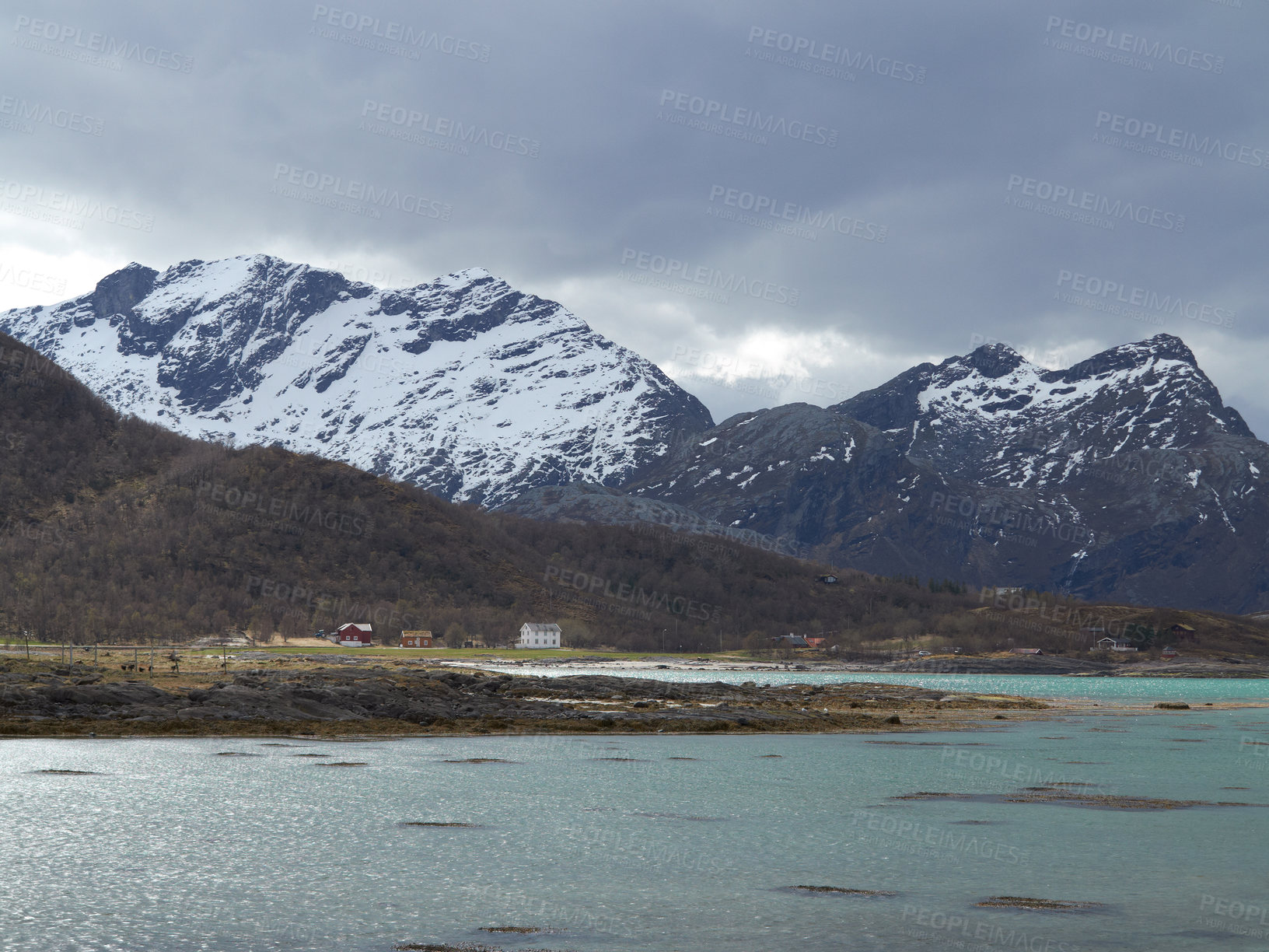 Buy stock photo Landscape view of mountain snow and a lake fjord in polar and arctic circle of Norway. Snowcapped terrain and hills in remote area with clouds in cold winter. Traveling overseas for holiday, vacation