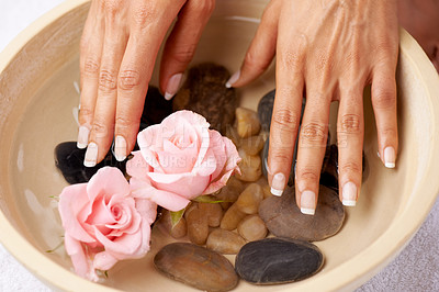 Buy stock photo Skincare, flowers and hands of woman in water bowl for cleaning or hygiene. Floral therapy, spa treatment and female soak hand and washing with pink roses and stones for detox, beauty and manicure.