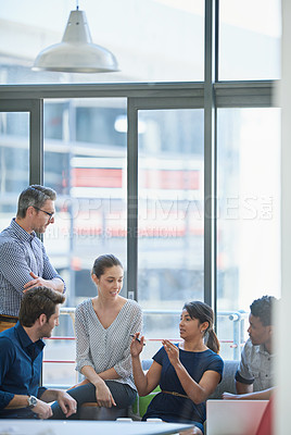 Buy stock photo Shot of a group of office workers talking together in a meeting room