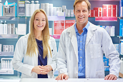 Buy stock photo Shot of two clinicians standing at the counter of a cosmetics store