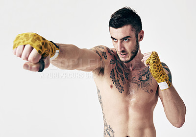Buy stock photo Angry man, fight swing and punch for martial arts, self defense and fitness for physical strength and exercise in studio. Person, glove bandage and tattoos for combat and recreation sport on mockup