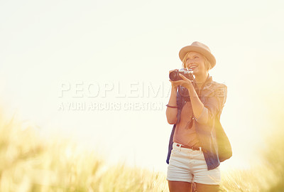 Buy stock photo Outdoor, sunshine and woman with a camera, photographer and travelling with happiness, lens flare and adventure. Trip, photography or girl with nature, field or summer with vacation, picture or smile