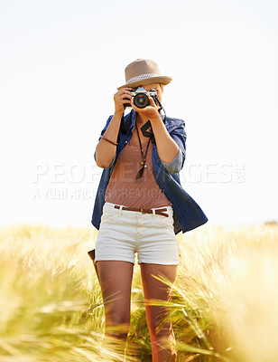 Buy stock photo Field, photographer and woman with camera, sunshine and nature with spring, environment and travel. Person, outdoor and girl with equipment, summer and freelancer shooting creative shots with picture