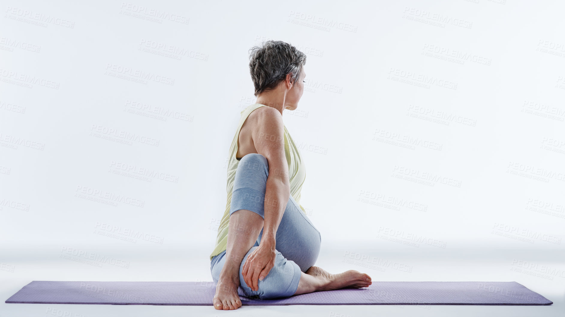 Buy stock photo Mature woman, stretching and yoga with twist on mat for zen or exercise on a white studio background. Female person, yogi or active model in fitness, practice or side pose for mindfulness or pilates