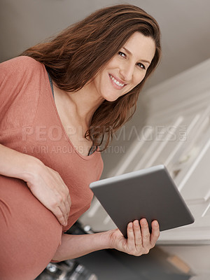 Buy stock photo Low angle portrait of a pregnant woman using a digital tablet