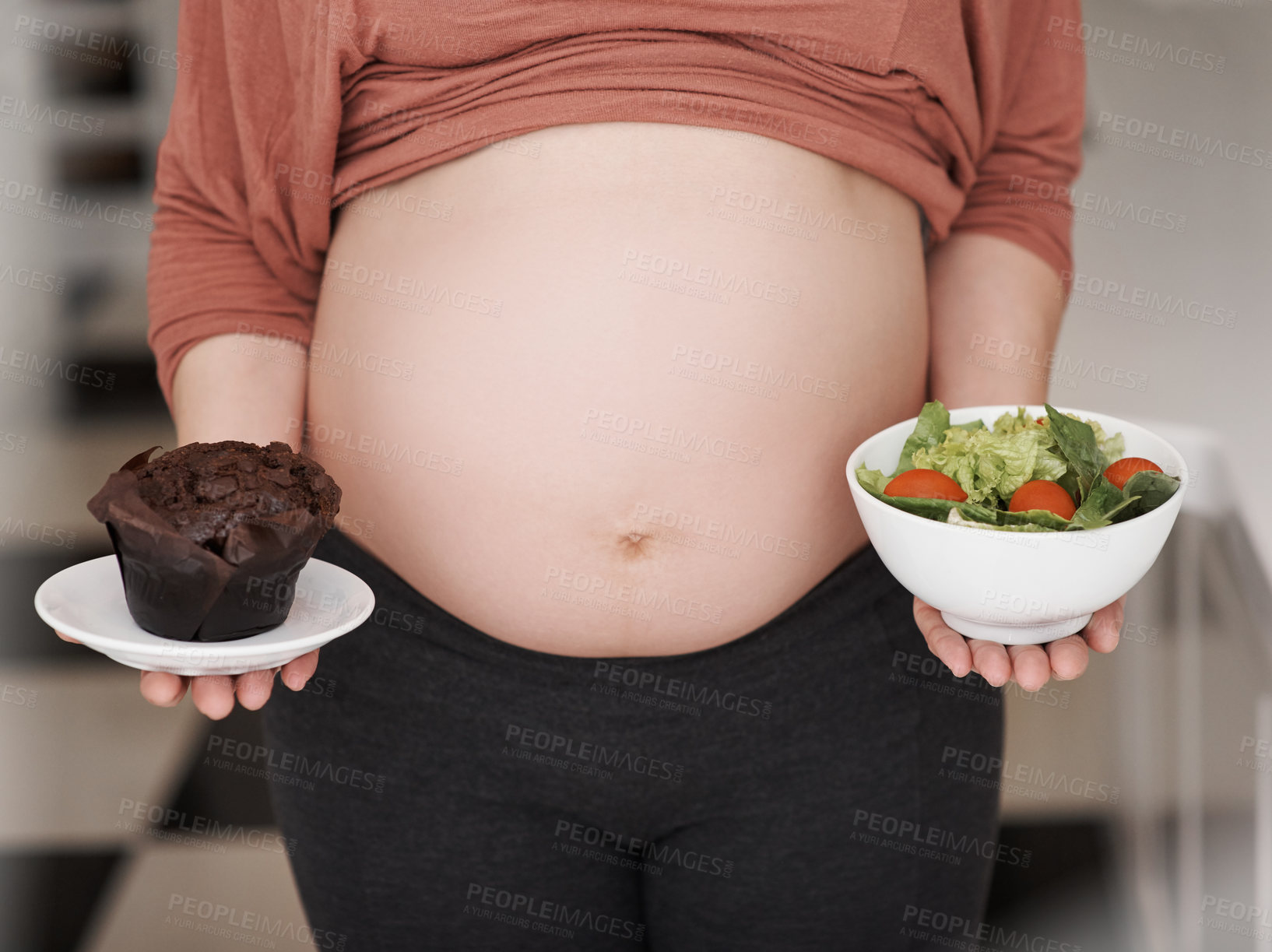 Buy stock photo Hands, pregnant and woman with choice of food for nutrition, prenatal diet and stomach wellness. Pregnancy, mother and decision for healthy meal, organic salad and temptation with cupcake in home