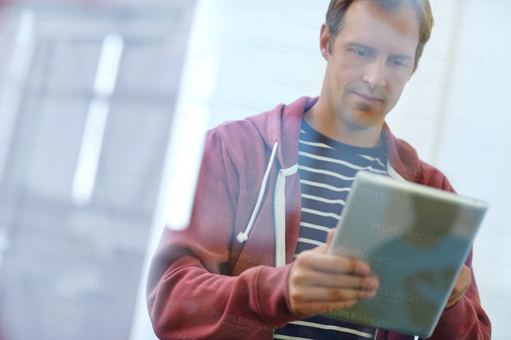 Buy stock photo Shot of a designer using a digital tablet while working in an office