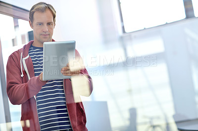 Buy stock photo Shot of a designer using a digital tablet while working in an office