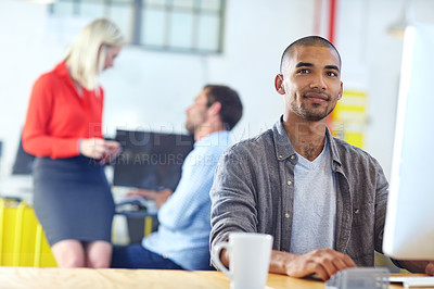 Buy stock photo Portrait of a designer at work on a computer with colleagues in the background