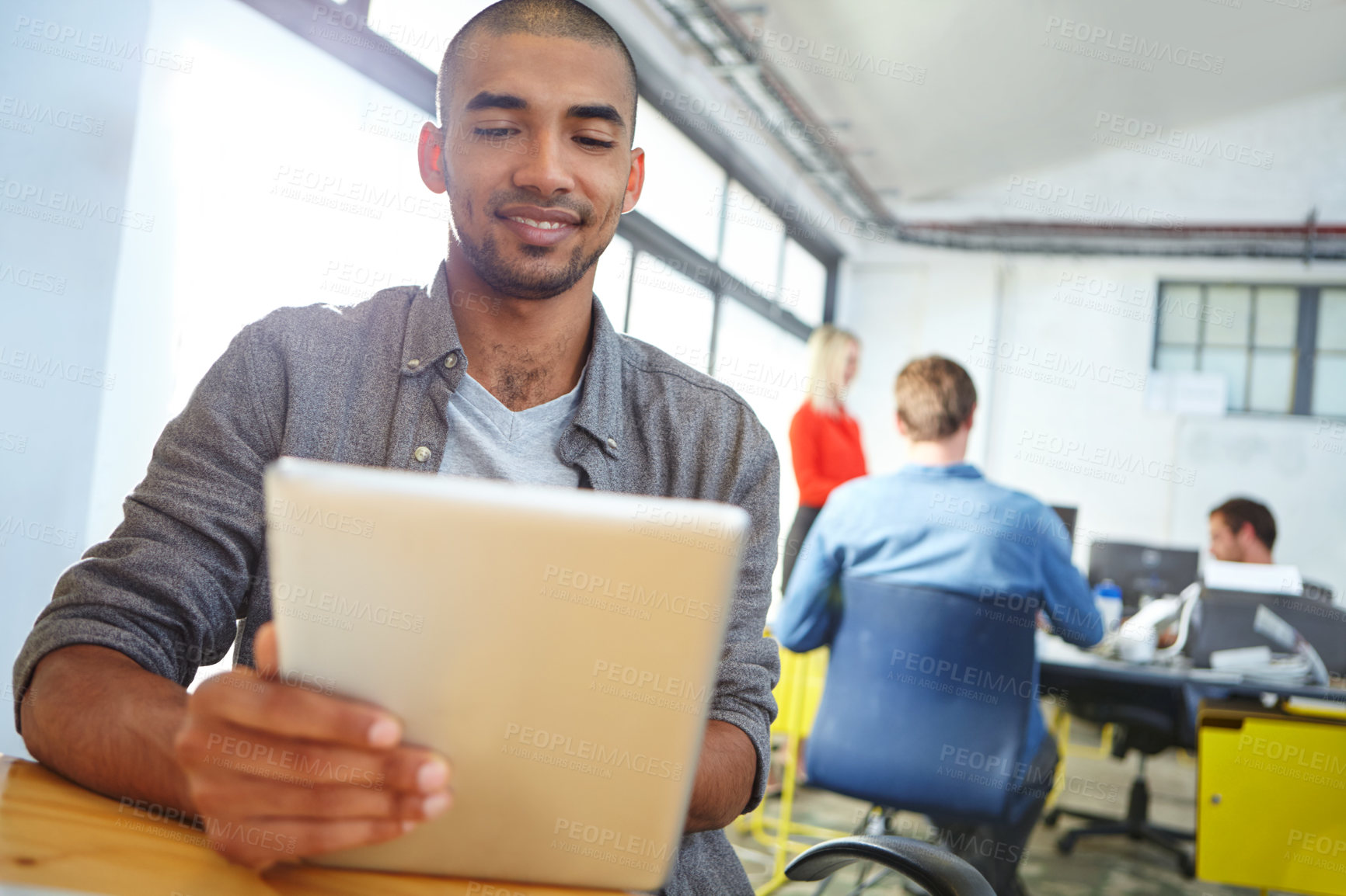 Buy stock photo Shot of a designer using a digital tablet while working in an office