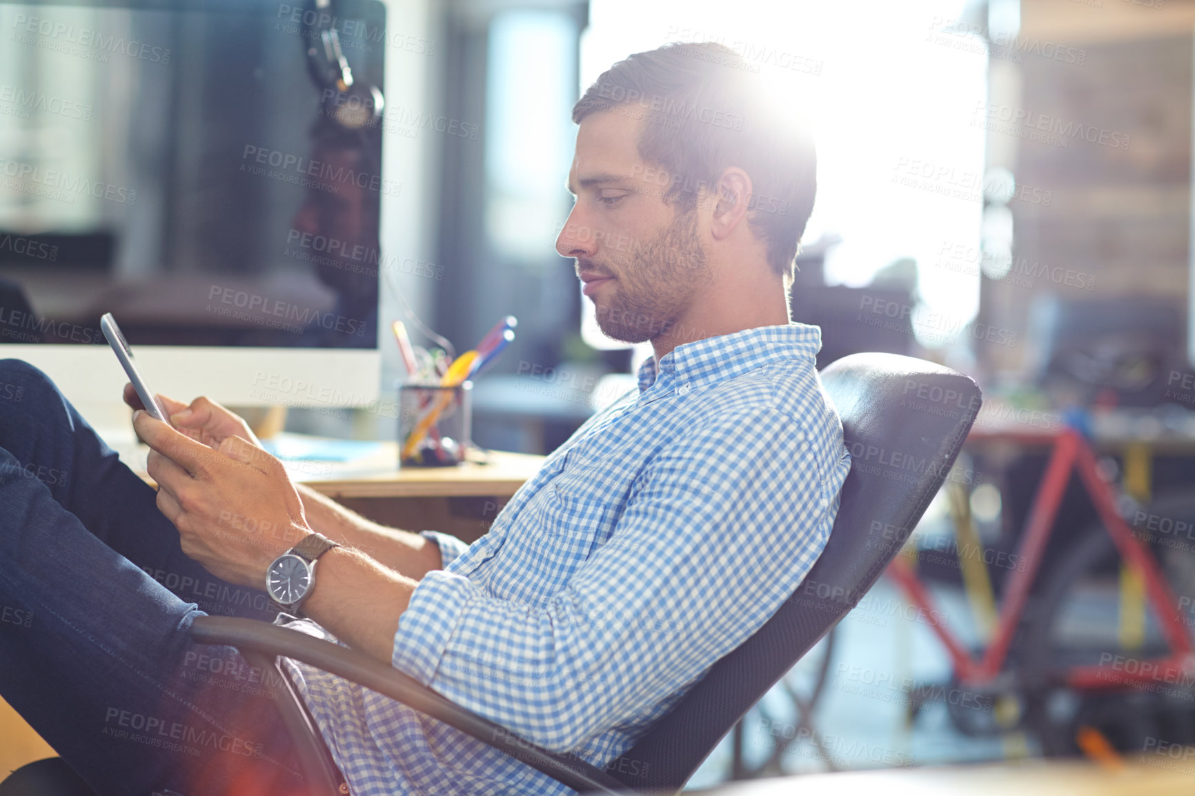 Buy stock photo Shot of a designer using a digital tablet while working in an office