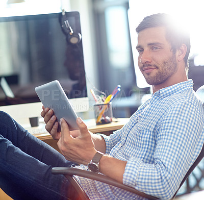 Buy stock photo Shot of a designer using a digital tablet while working in an office