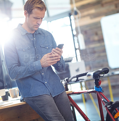 Buy stock photo Shot of designer using a cellphone while at work in an office