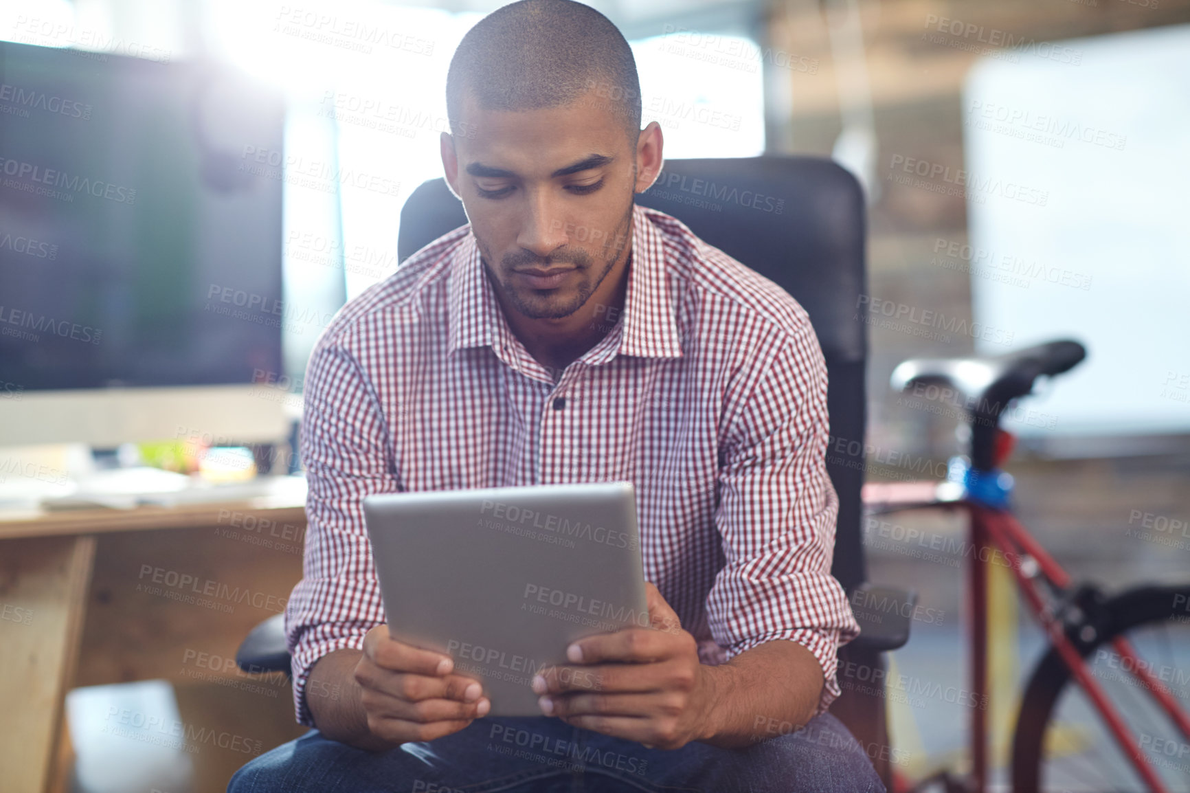 Buy stock photo Shot of a designer using a digital tablet while working in an office