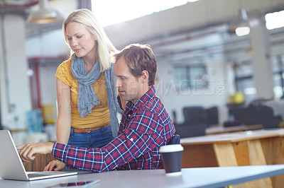 Buy stock photo Shot of two designers working on a laptop in an office