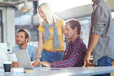 Buy stock photo Shot of a diverse group of designers working on a laptop in an office