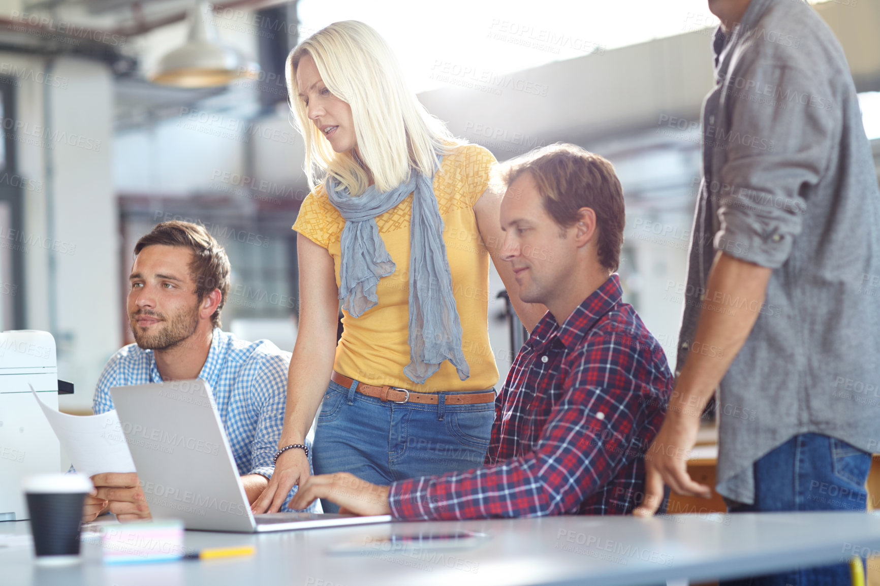 Buy stock photo Shot of a diverse group of designers working on a laptop in an office