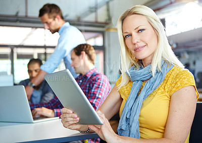 Buy stock photo Portrait of a young designer using a digital tablet with colleagues in the background