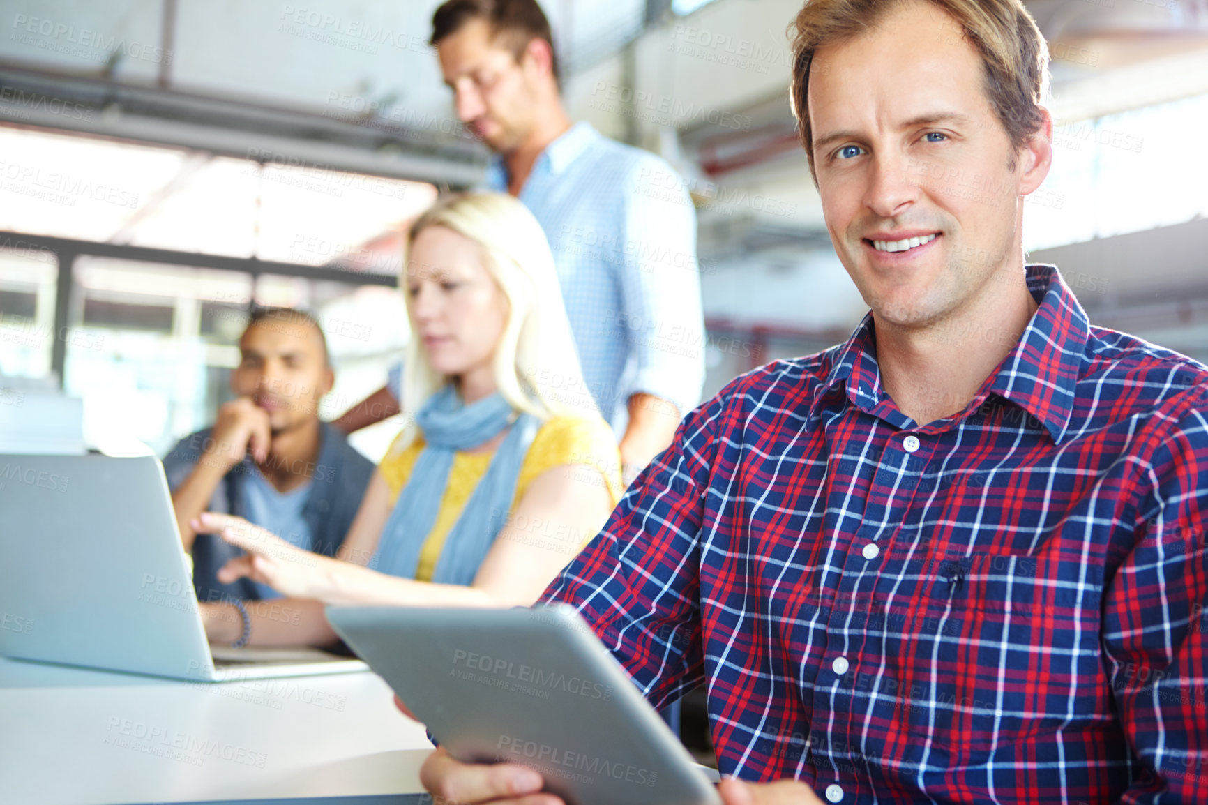 Buy stock photo Portrait of a designer using a digital tablet with colleagues in the background