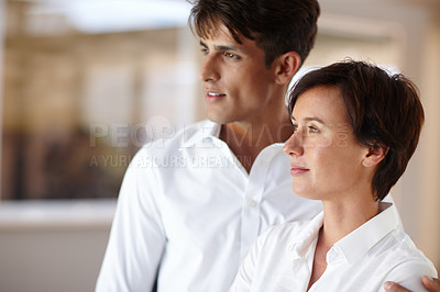 Buy stock photo Shot of a loving couple looking away thoughtfully