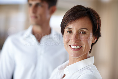 Buy stock photo Portrait of an attractive businesswoman with a colleage standing in the background