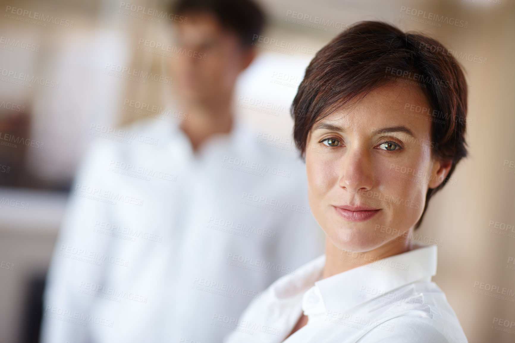 Buy stock photo Portrait of a confident businesswoman with a colleage standing in the background