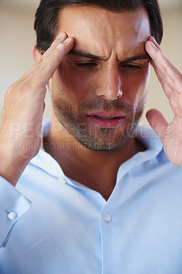 Buy stock photo Cropped shot of a businessman suffering from a headache and rubbing his temples 