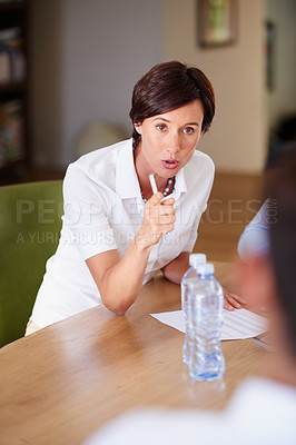 Buy stock photo Shot of a businesswoman pointing angrily at an employee during a meeting