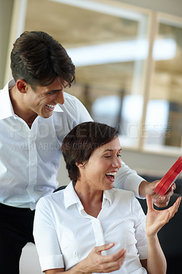 Buy stock photo Shot of a young man giving his girlfriend a box of chocolates