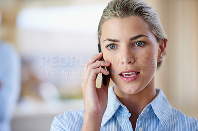 Buy stock photo Shot of a young businesswoman talking on the phone in the office