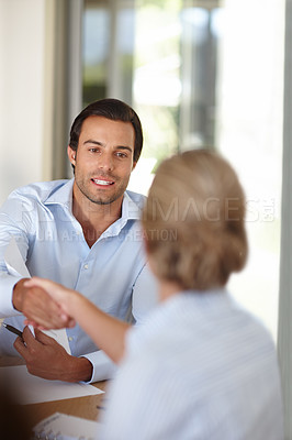 Buy stock photo Shot of a handsome businessman shaking hands with a colleague