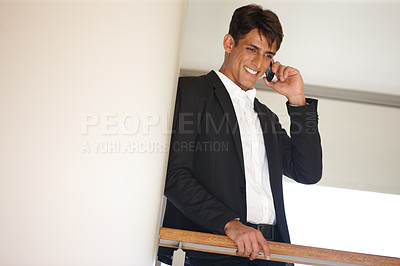 Buy stock photo Business man, phone call and happy on balcony for contact, lead or mockup space by wall at real estate agency. Person, realtor and smile with smartphone for deal, talk and excited for property sale