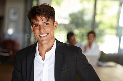 Buy stock photo Portrait of a handsome young businessman with his colleagues sitting in the background