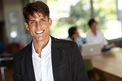 Buy stock photo Portrait of a handsome young businessman with his colleagues sitting in the background