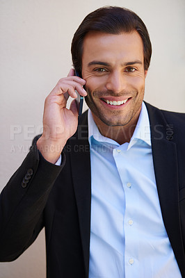 Buy stock photo Portrait of a handsome businessman smiling while talking on the phone