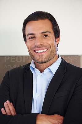 Buy stock photo Portrait of a handsome businessman smiling while standing with his arms crossed