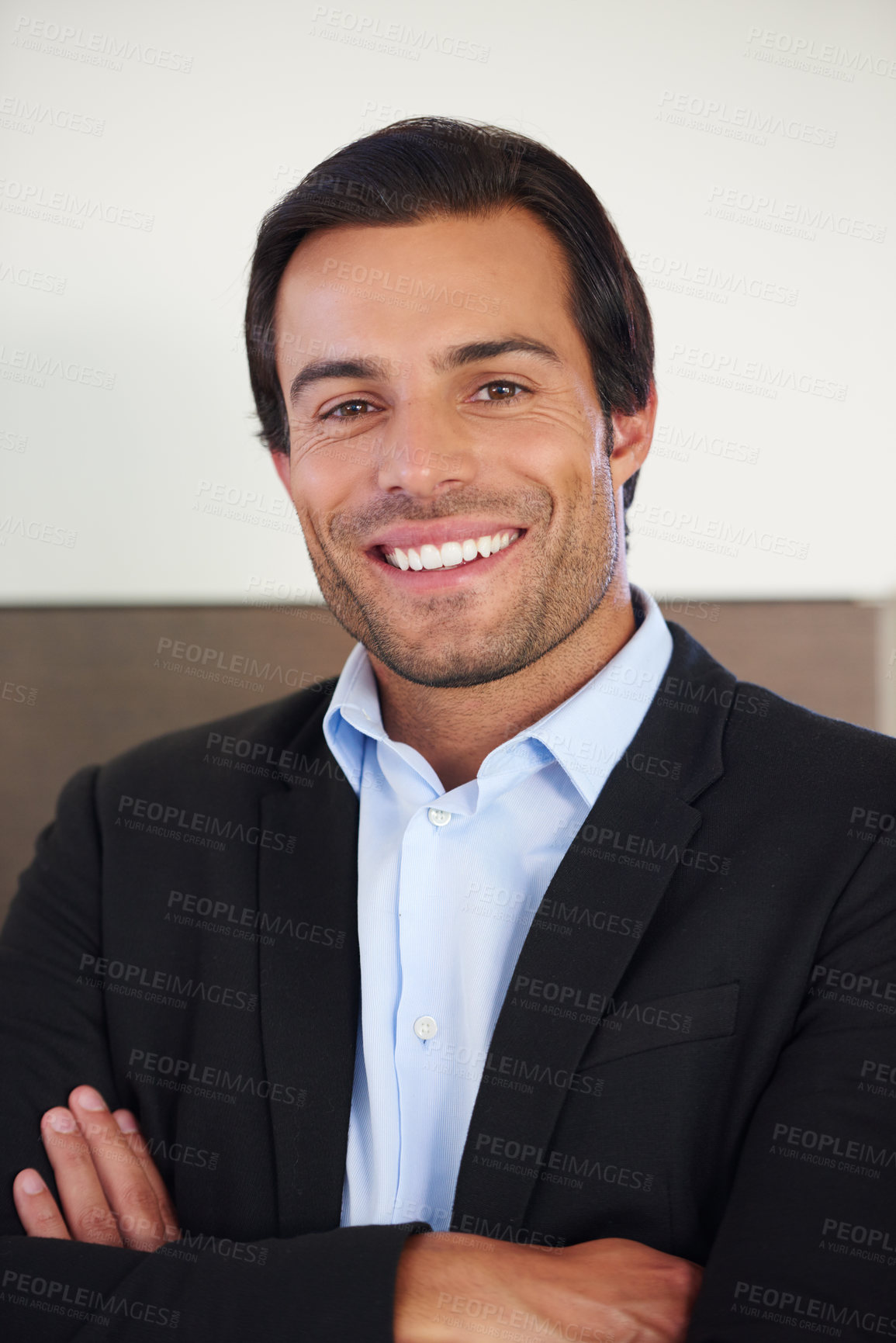 Buy stock photo Portrait of a handsome businessman smiling while standing with his arms crossed