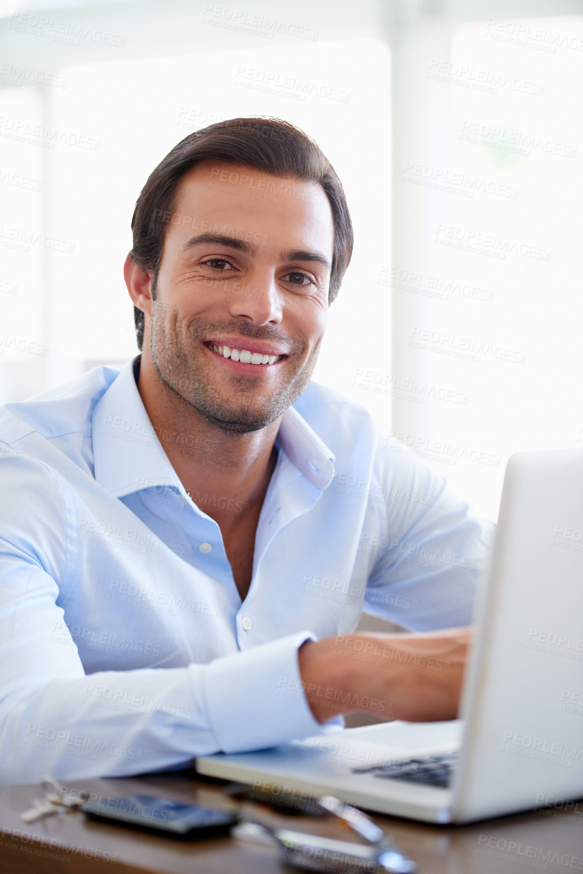 Buy stock photo Portrait of a handsome businessman using his laptop in the office