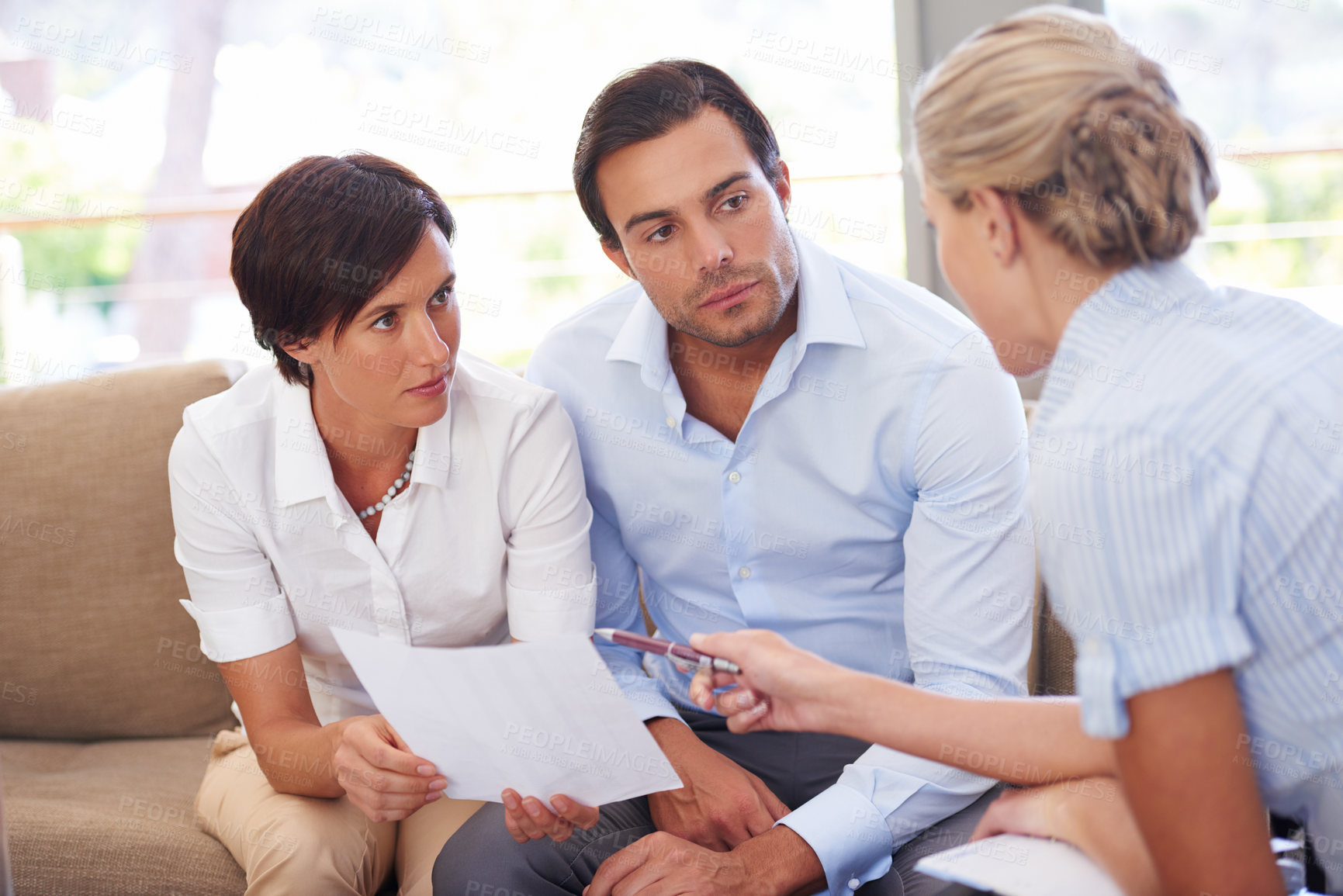 Buy stock photo Shot of a financial advisor explaining documents to a couple