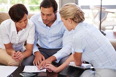 Buy stock photo Shot of a financial advisor explaining documents to a couple