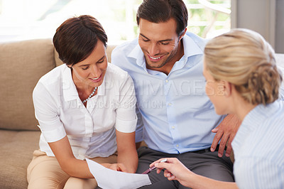 Buy stock photo Shot of a financial advisor explaining documents to a couple