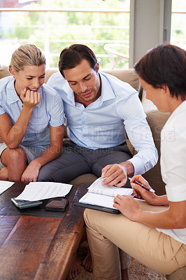 Buy stock photo Shot of a couple getting advice about their finances from their financial planner