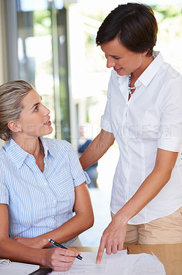 Buy stock photo Shot of a businesswoman discussing work with a colleague at the office