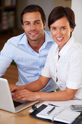 Buy stock photo Shot of two colleagues working together at a laptop