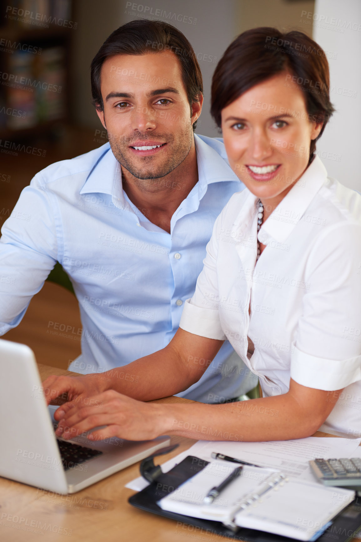 Buy stock photo Shot of two colleagues working together at a laptop