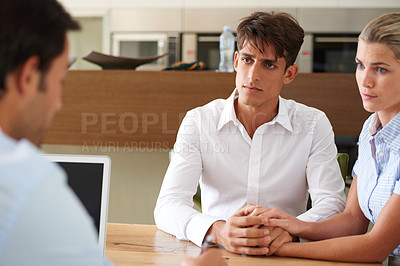 Buy stock photo Shot of a young couple meeting with a consultant