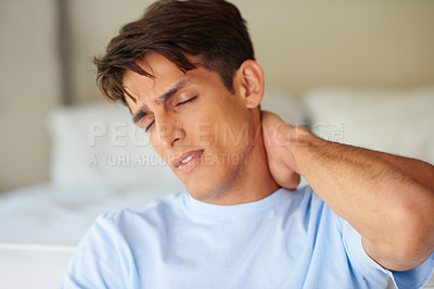 Buy stock photo Shot of a handsome young man suffering from severe neck pain