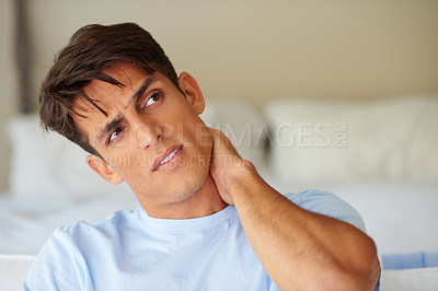 Buy stock photo Shot of a handsome young man suffering from severe neck pain