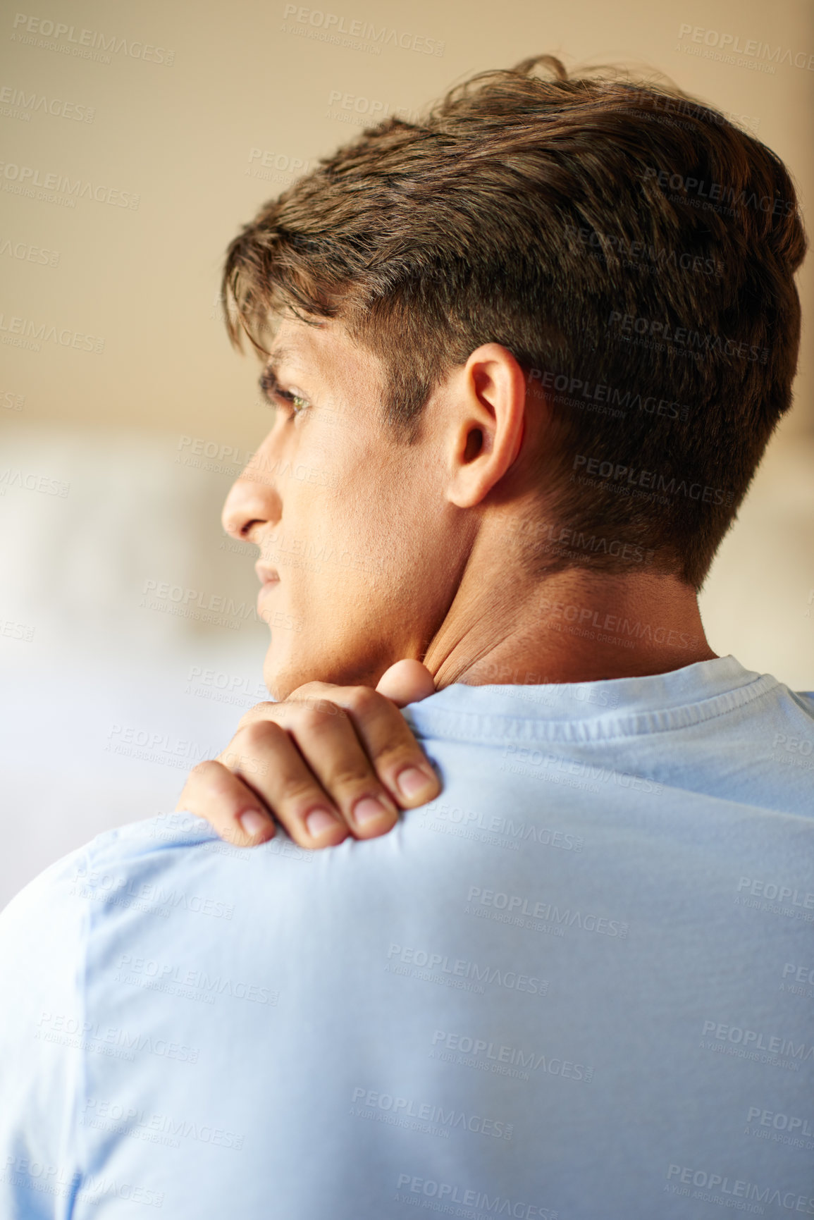 Buy stock photo Rearview shot of a young man suffering from a neck pain